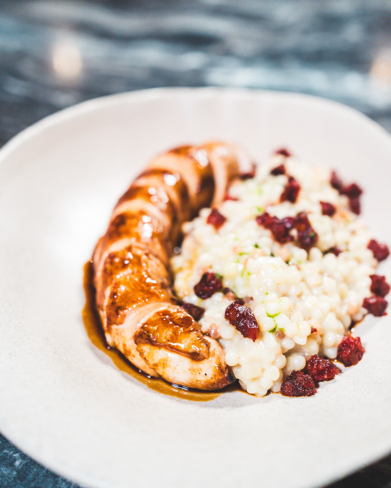 Slow-cooked chicken on creamy fregola with cured-tomato crumb.